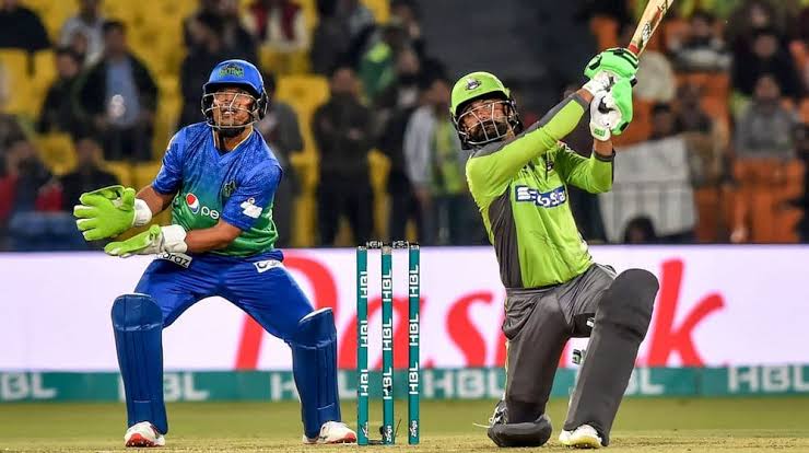 Cricket batsman hitting ball during night game